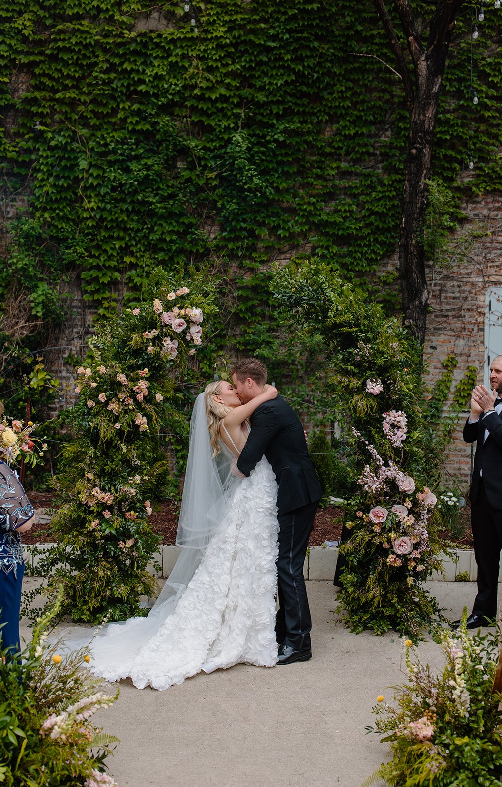 Couple beneath a blooming garden wall