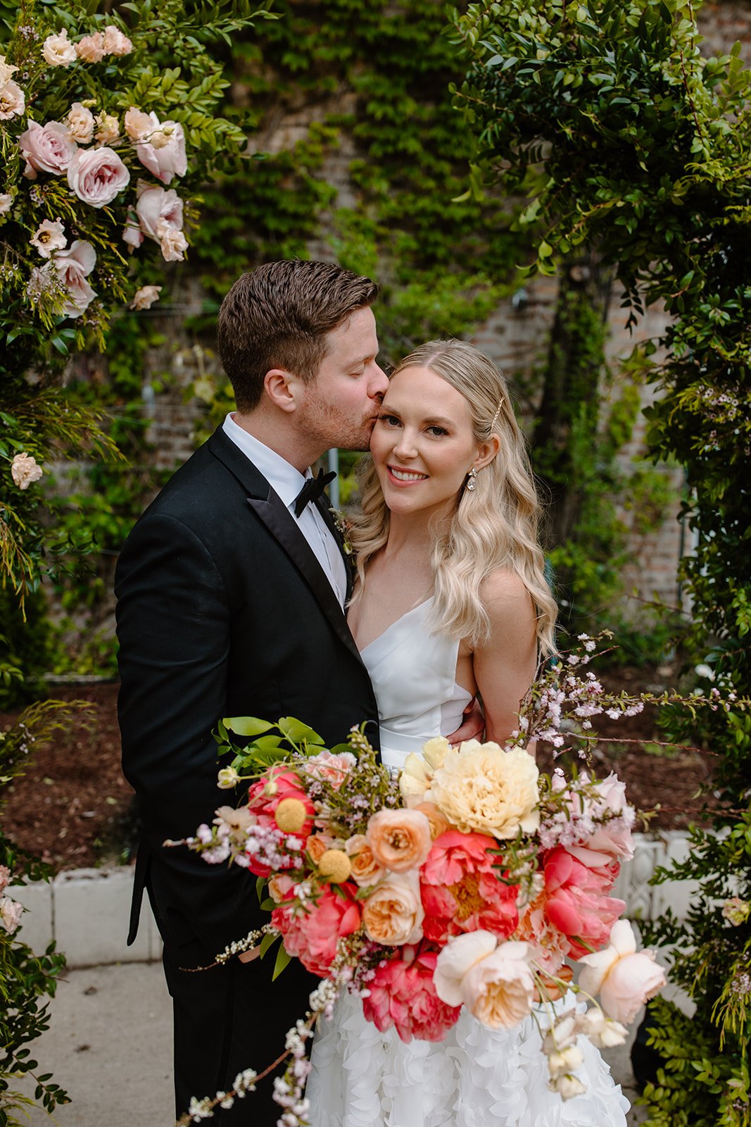 Couple with a lush pink and coral bridal bouquet