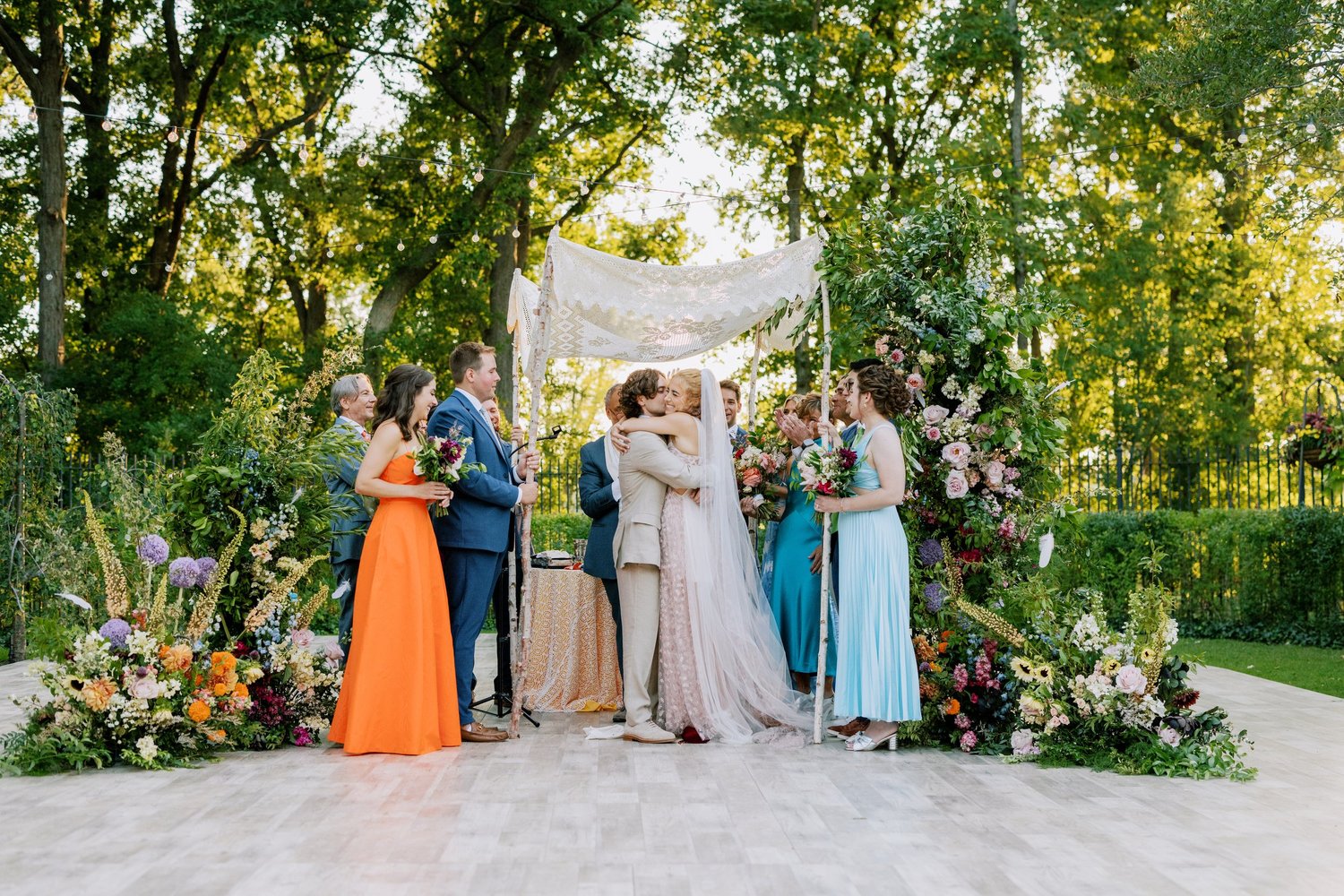Garden ceremony beneath a floral chuppah
